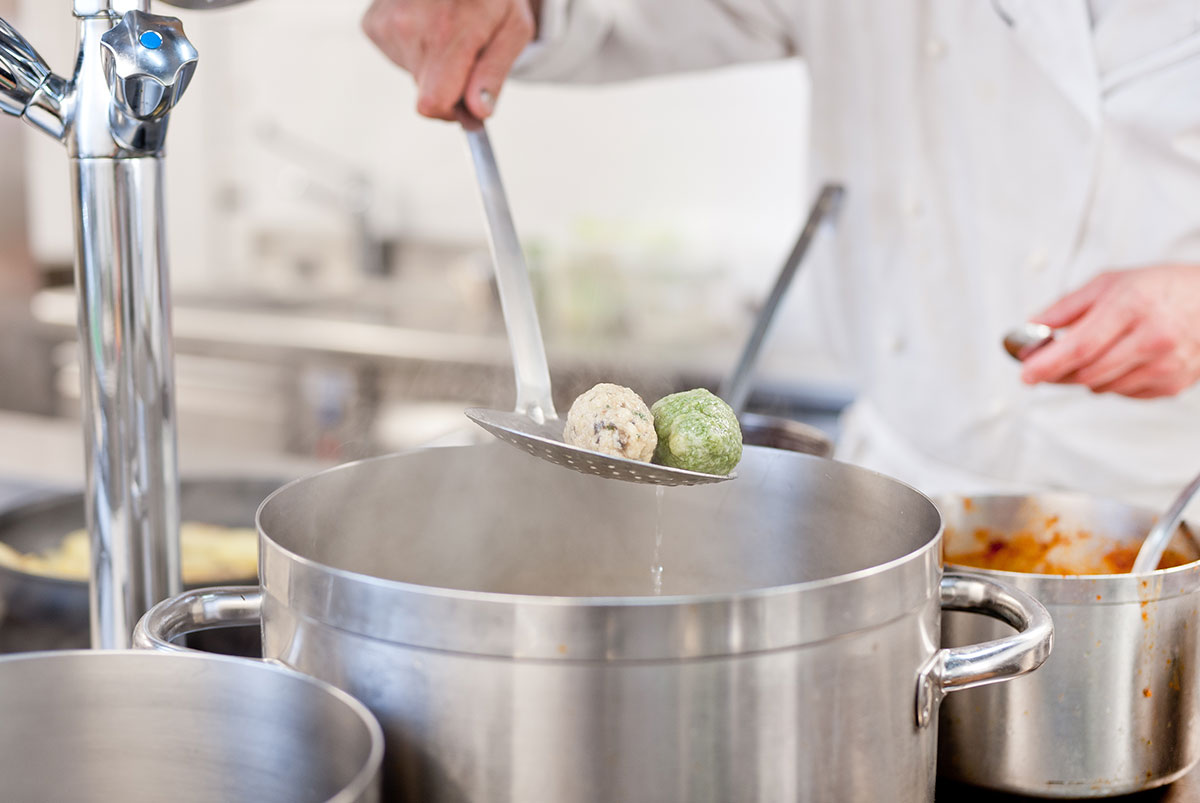 Chef scooping cheese & spinach dumplings - Hotel Gasthof zur Sonne