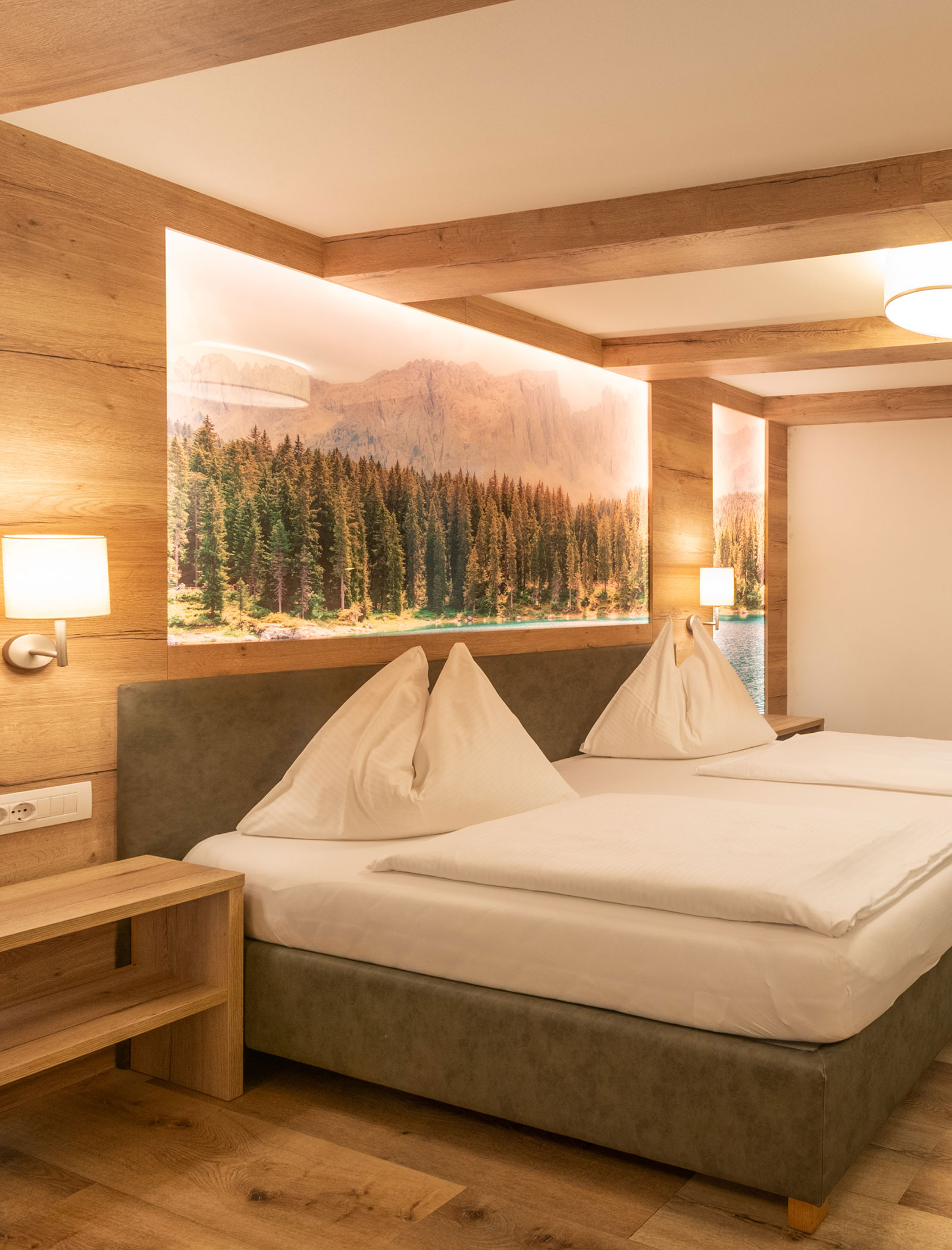 Gemütliches Hotelzimmer mit zwei Einzelbetten, Holzausstattung und einem großen Wandbild mit Waldmotiv hinter dem Kopfteil. - Hotel Zur Sonne